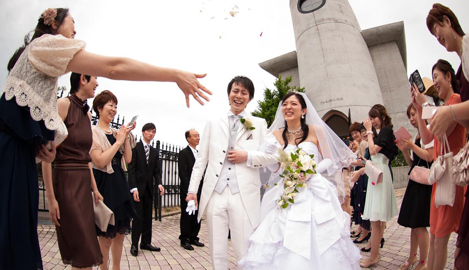 チャペルの外にて来賓の皆様にフラワーシャワーで祝福される花嫁と花婿のお写真
